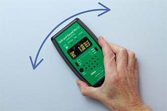Green microwave meter against a blue wall.